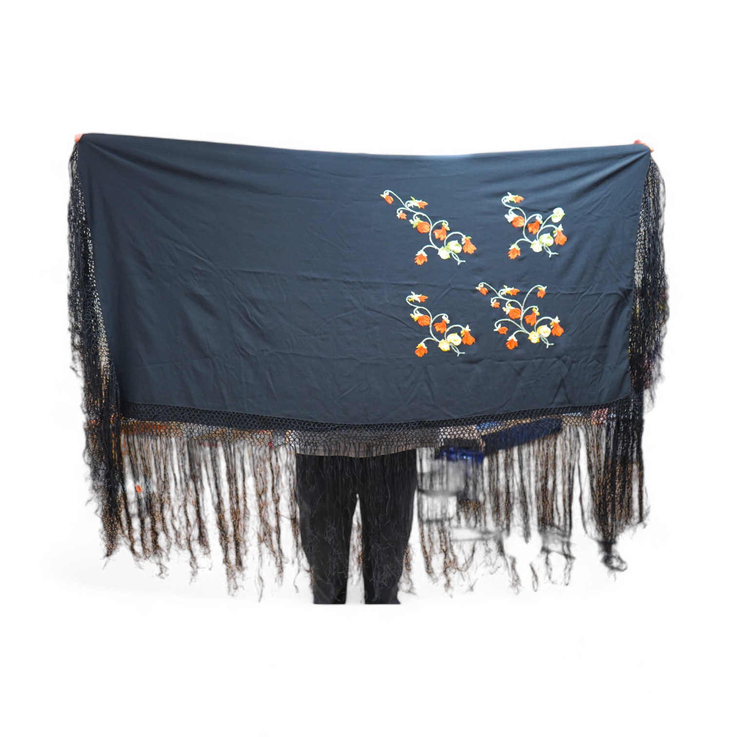 A black silk embroidered shawl with orange yellow and green polychrome embroidery to one corner, edged with long silk fringe. Condition - fabric good, some marks to silk may possibly sponge off